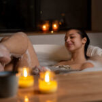 Uma mulher relaxa em um banho de ofurô e lê um livro.