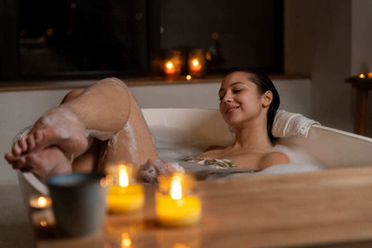 Uma mulher relaxa em um banho de ofurô e lê um livro.