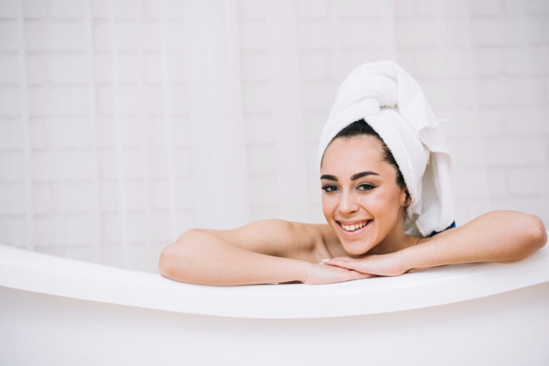 Uma jovem sorridente relaxa em uma banheira.