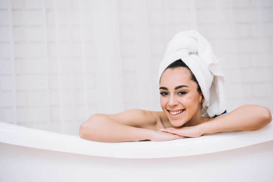 Uma jovem sorridente relaxa em uma banheira.